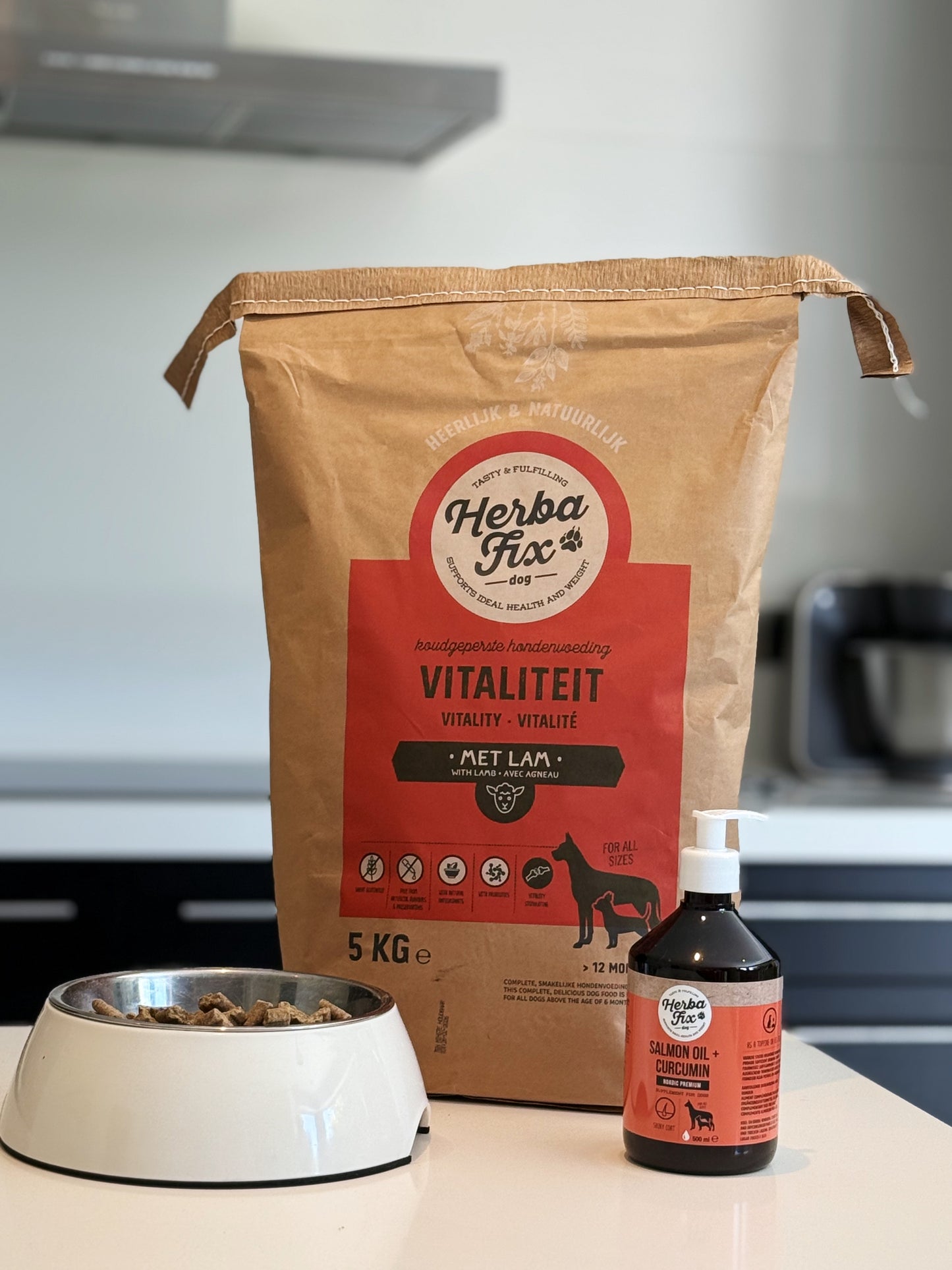 Zak Herbafix Vitaliteit 5kg in de keuken naast fles Herbafix Zalmolie voor de perfecte combinatie